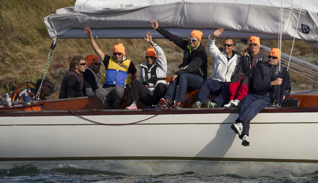 Flera personer sitter på en båt och vinkar. Alla ser glada ut.