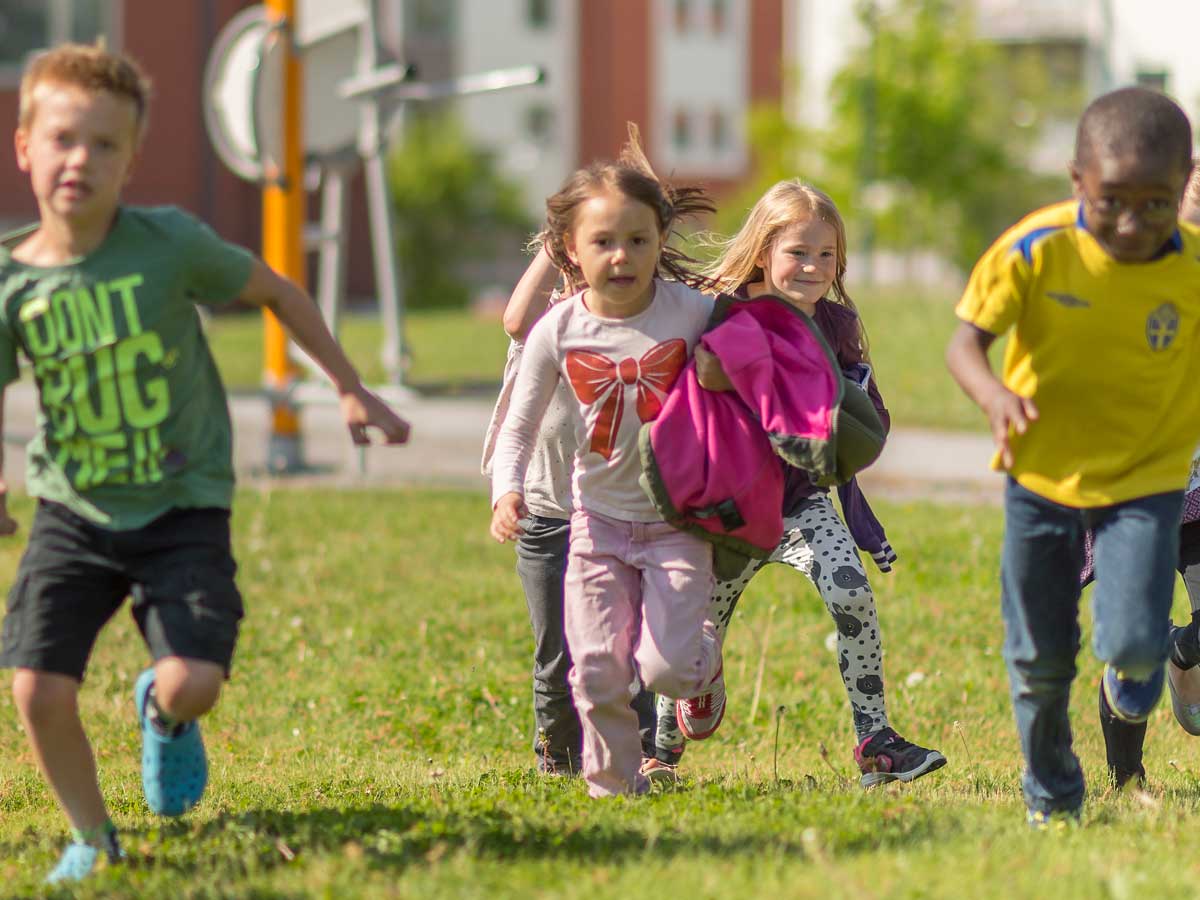 Barn som springer mot kameran på en gräsmatta