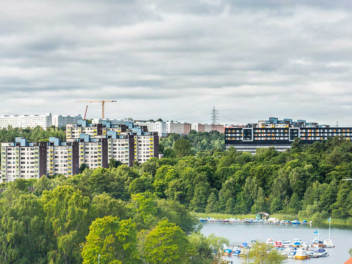 Bild på höghus längs vattnet och båtar i hamn