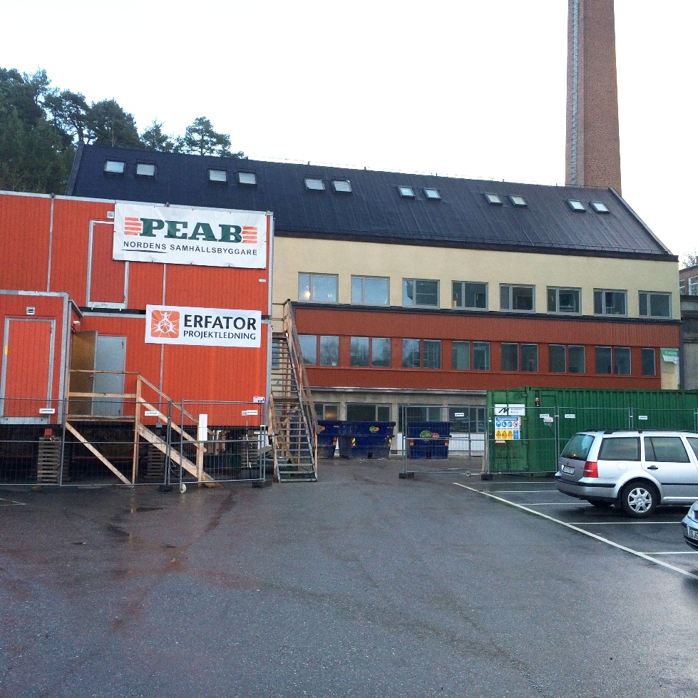 En byggarbetsplats med containrar, på dem finns skyltar: PEAB & Erfator.
