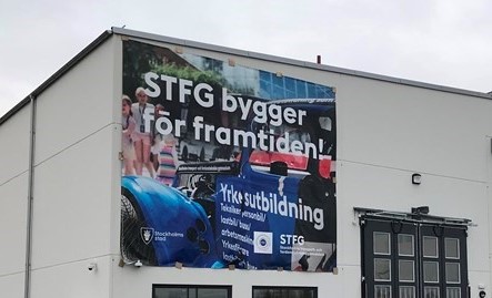 En vit byggnad med en skylt på.