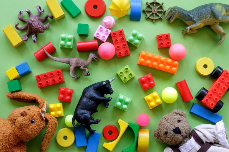 Barnleksaler: lego, nallar ligger mot en grön bakgrud.